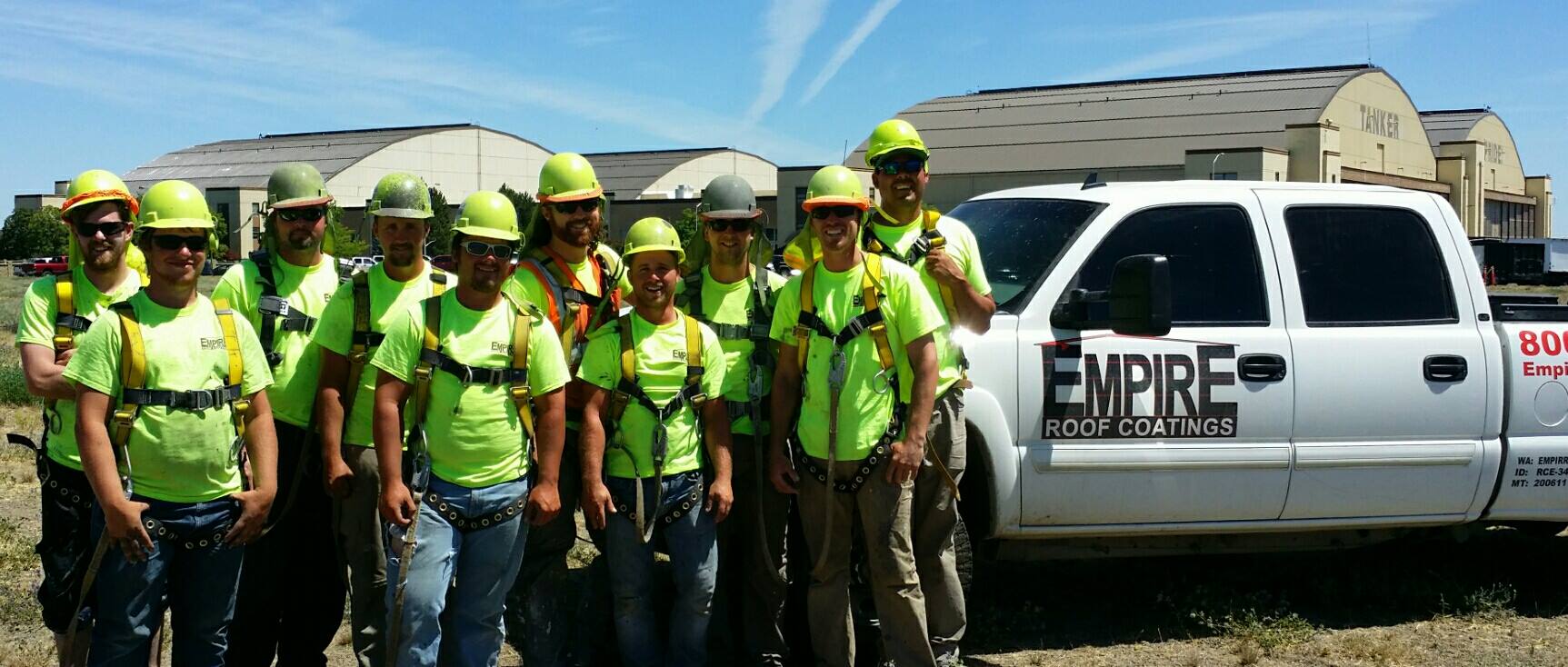 Empire Roof Coatings crew wearing safety harnesses on a commercial job site